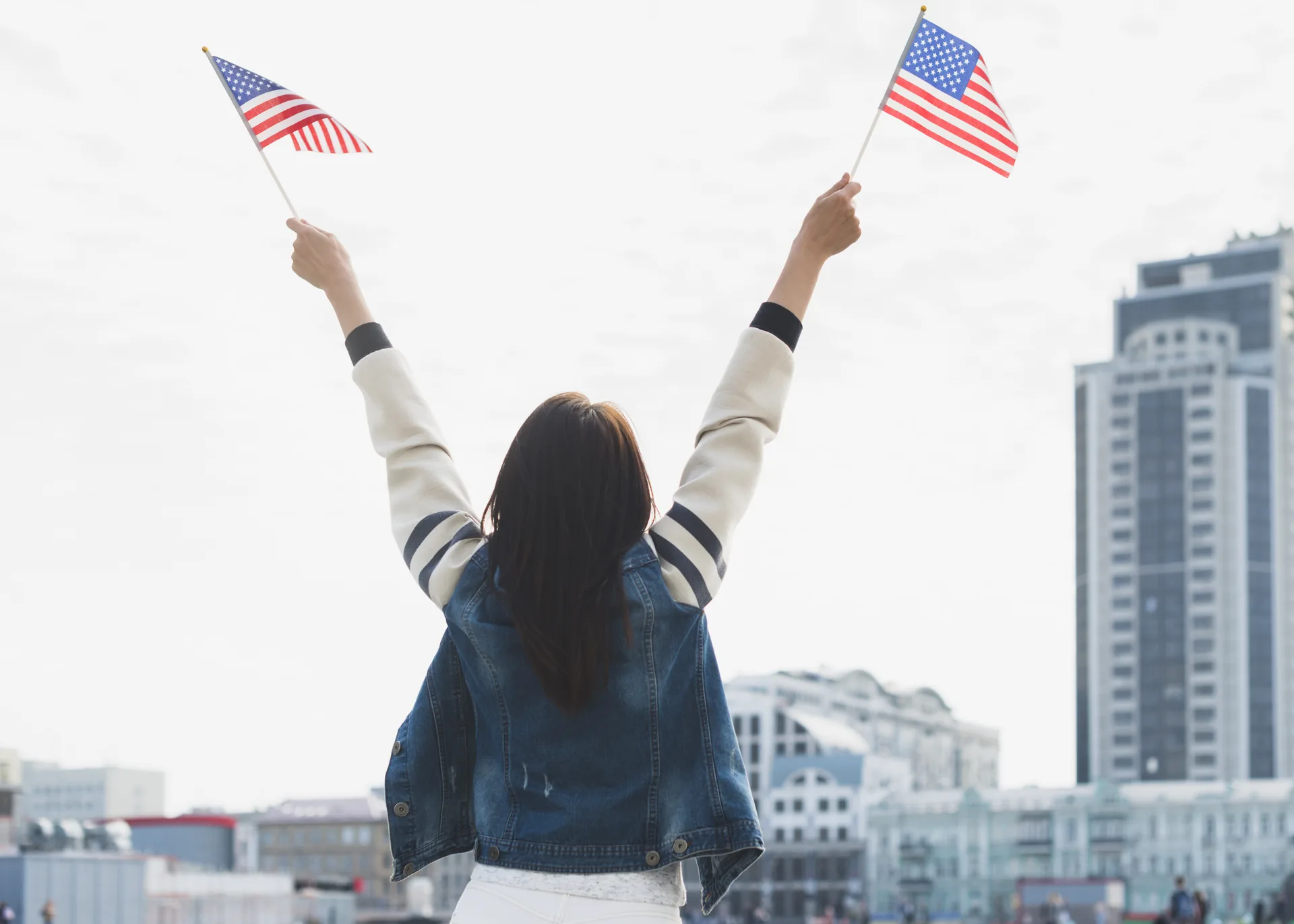 woman waving american flags city